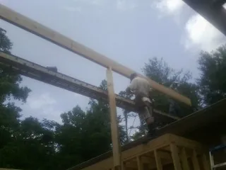 Carpenter setting a ridge beam over a new addition frame — Ice Dam Removal by Roofing Brothers in Harrison Township