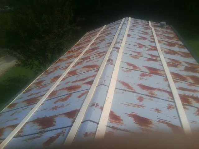 Rusted metal roof panels with new wood purlins before replacement — Storm Damage Roof Repair in Harrison Township by Roofing Brothers