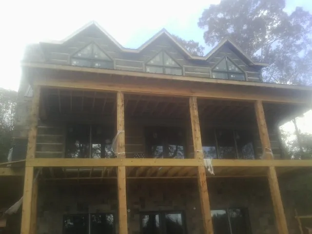 Dormers and porch framing on a large log home under construction — Roof Coating work by our crew in Harrison Township