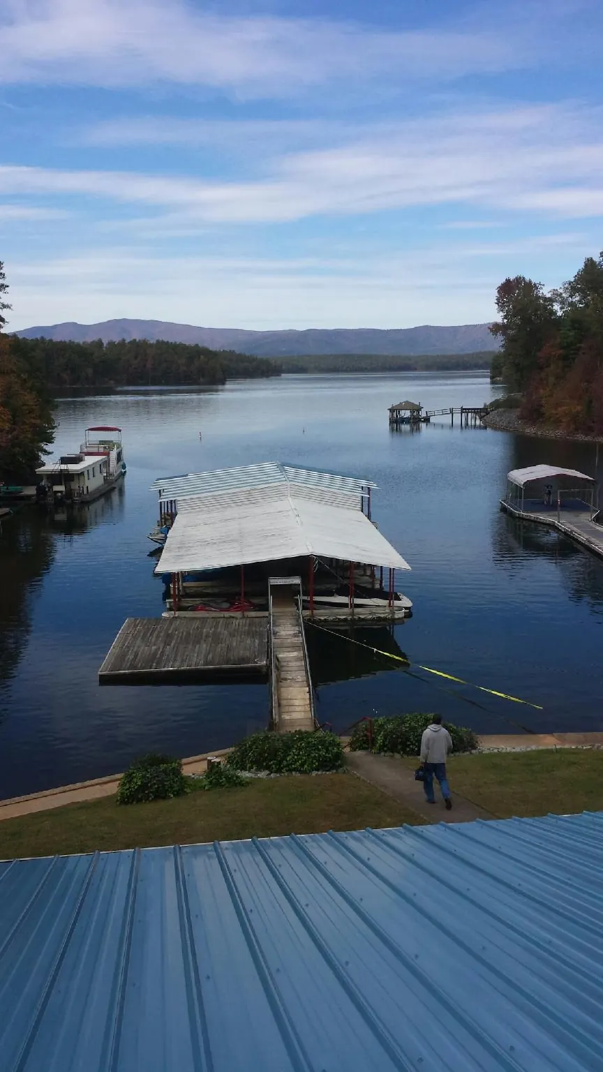 View across a lake from a newly installed blue metal roof in Harrison Township