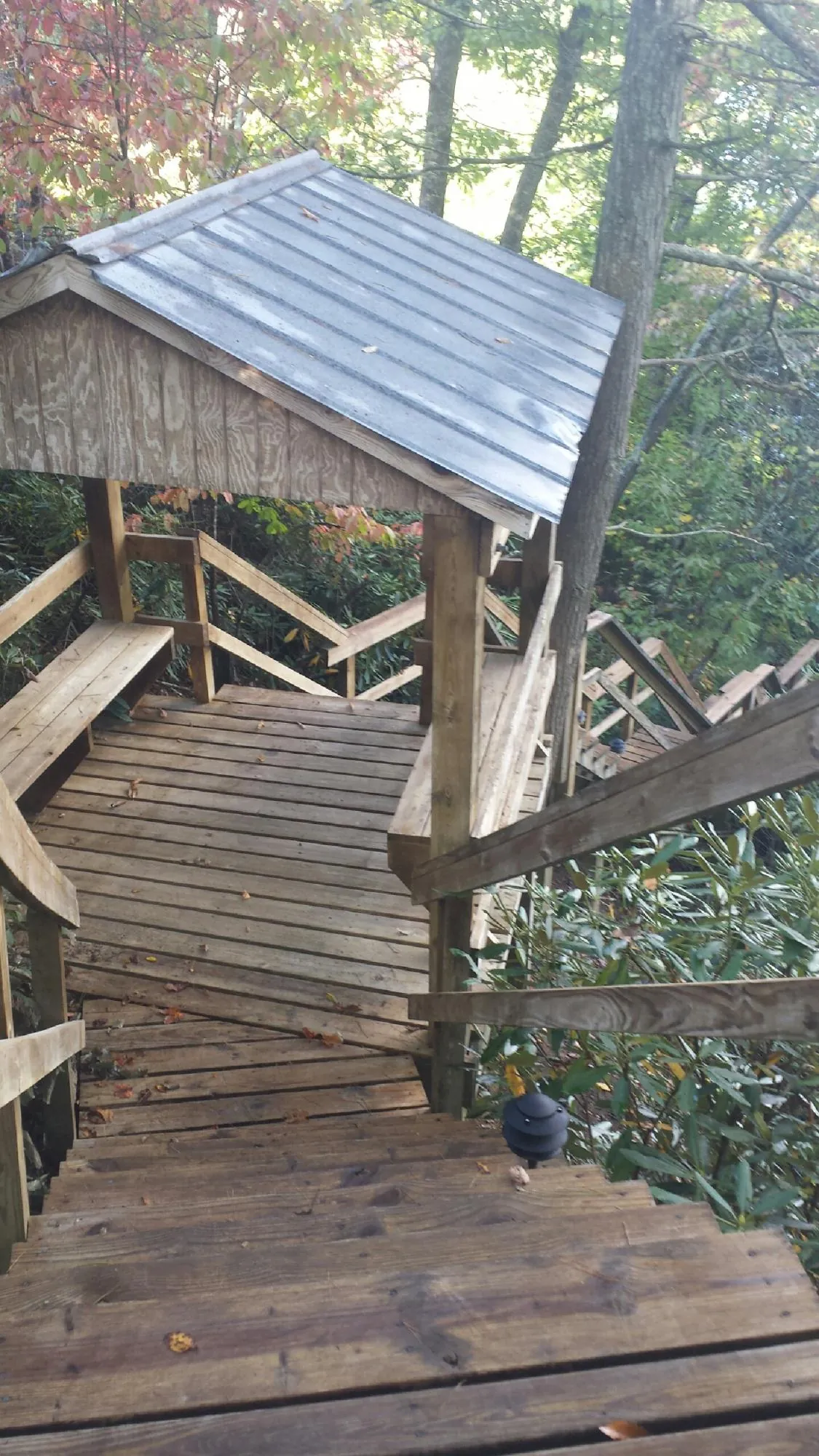 Metal roofed shelter over wooden steps on a wooded walkway — Skylight Repair & Installation work by our crew in Harrison Township
