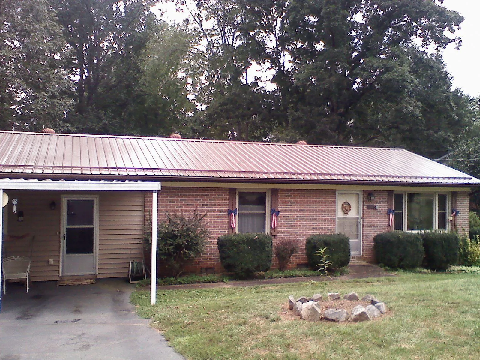 Bronze metal roof and carport on a brick ranch home — Roof Repair work by our crew in Harrison Township